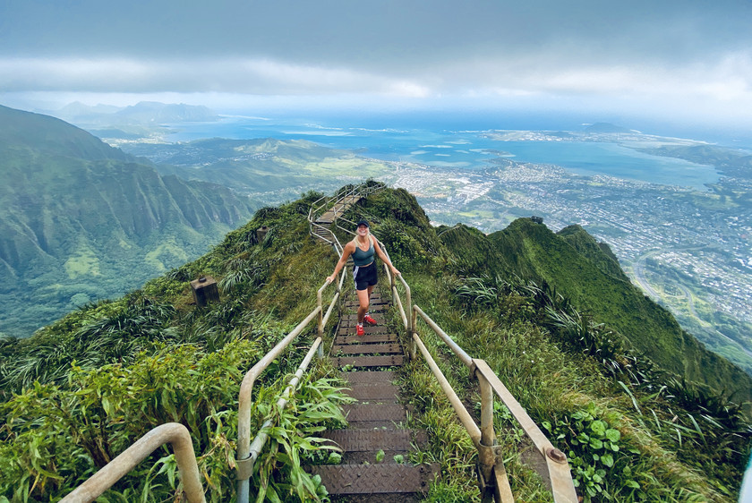 Studerende på bro med flot udsigt over bjerge på Hawai'i.