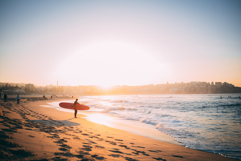 surfer at bondi beach sydney in the sunset
